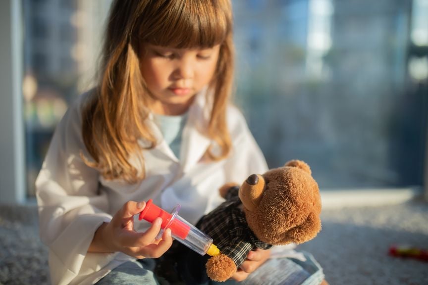 Mädchen gibt ihrem Teddybär eine Spritze