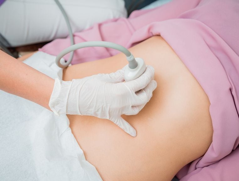 Ultraschallkopf auf dem Bauch einer Frau