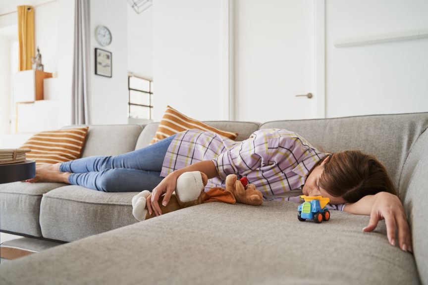 Erschöpfte Frau liegt auf dem Sofa