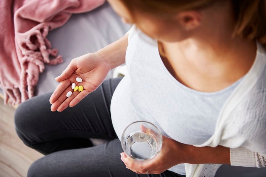 Schwangere mit Medikamenten in der Hand