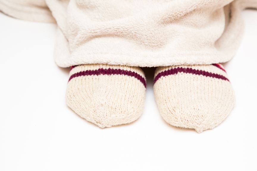 Füsse mit warmen Socken und Kuscheldecke