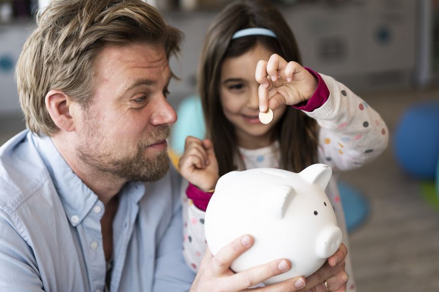 Vater mit Tochter und Sparschwein