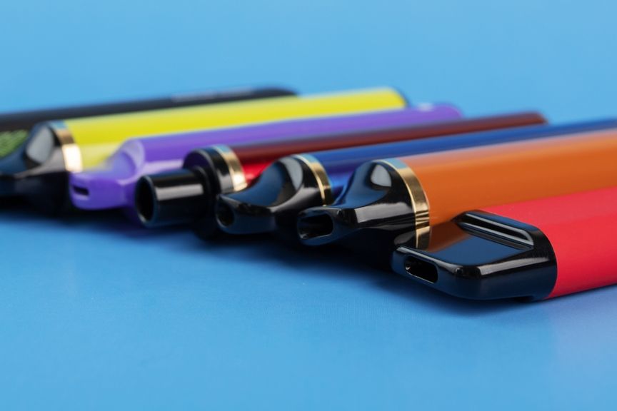 Verschiedenfarbige Vapes vor blauem Hintergrund
