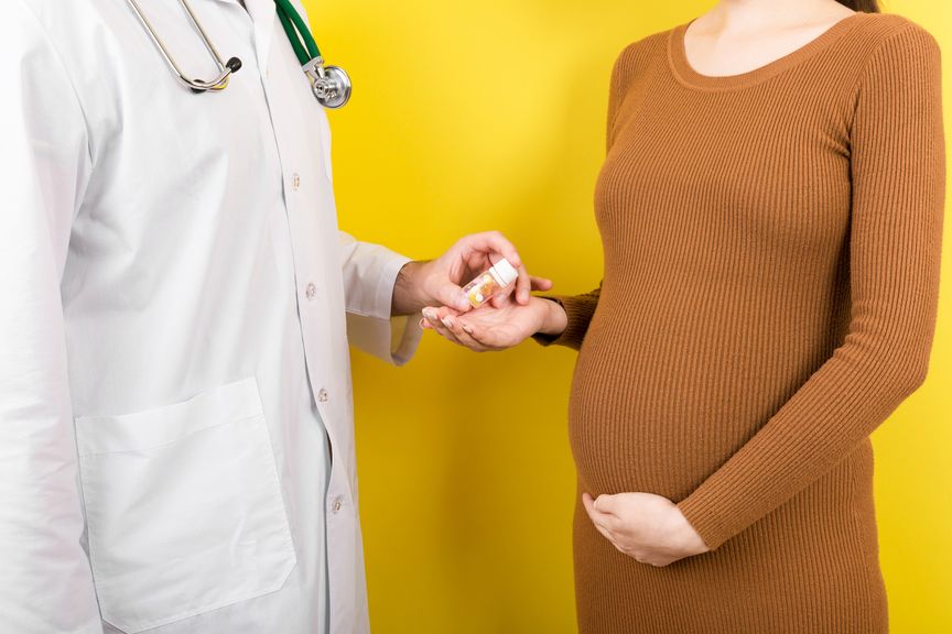 Arzt gibt einer Schwangeren ein Medikament