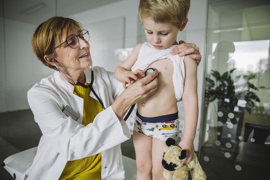 Ärztin untersucht Kind mit Stethoskop