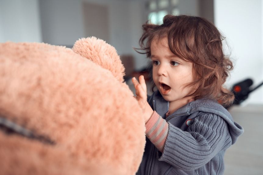 Kind spricht mit Teddybär