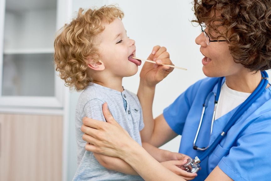 Ärztin schaut in den Kindermund