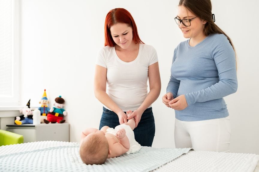 Mütter-/Väterberaterin zeigt der Mutter Babymassage