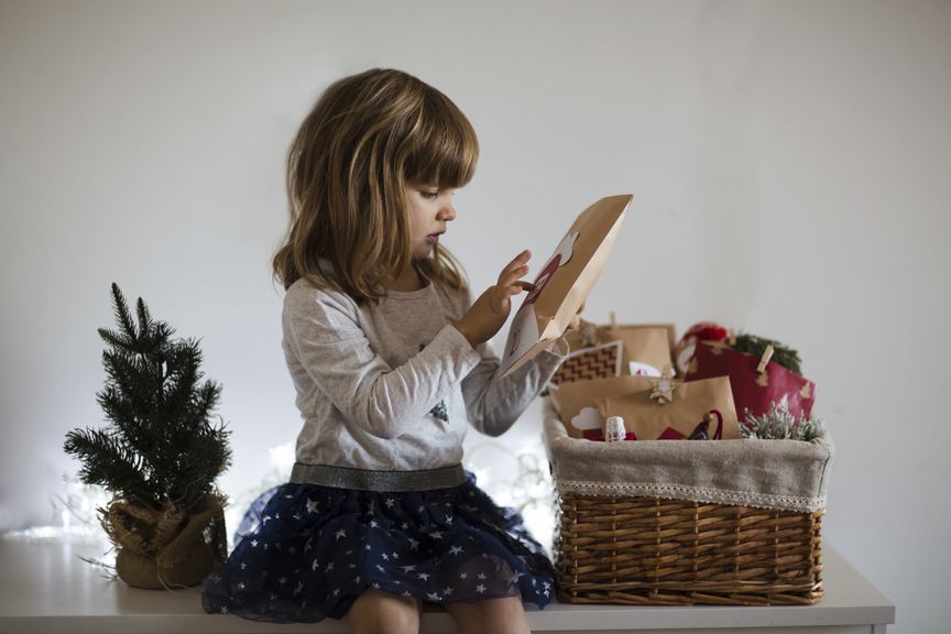 Kind öffnet ein Geschenk aus dem Adventskalender