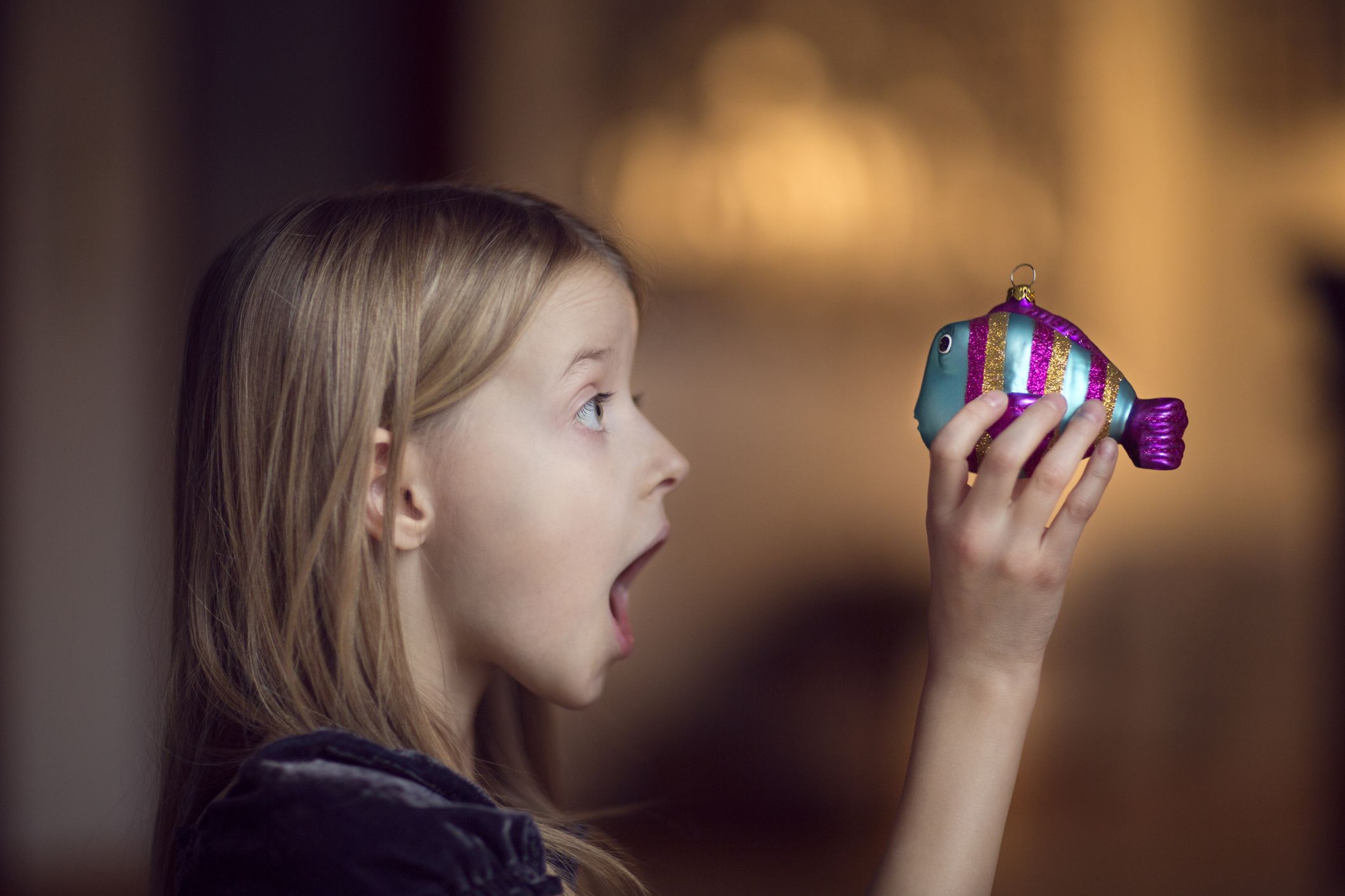 Kind hält Weihnachtsschmuck in der Hand