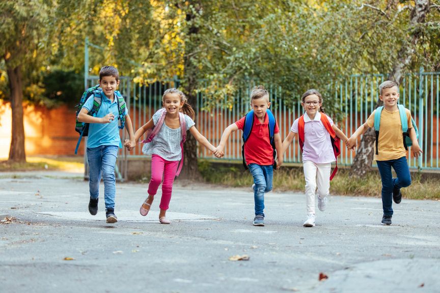 Gruppe von Schulkindern rennt über den Schulhof