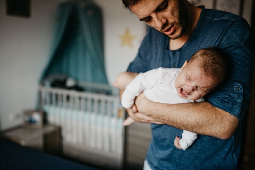 Vater hält sein Baby mit Bauchschmerzen