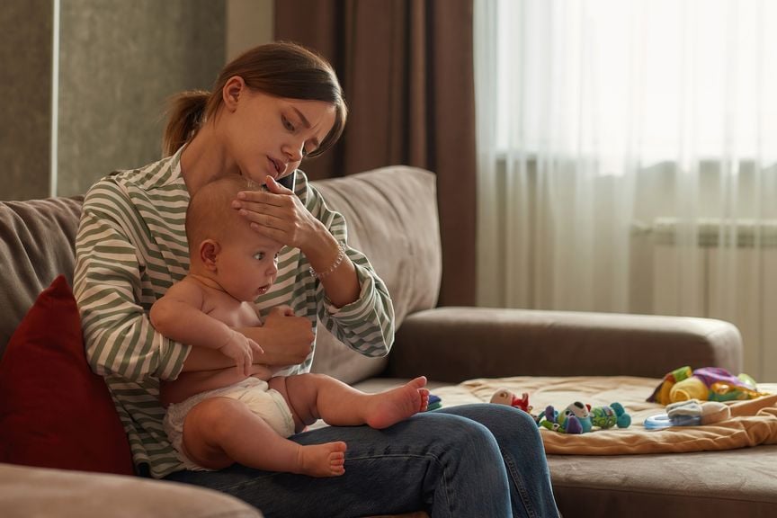 Mutter prüft die Temperatur ihres Kindes mit der Hand