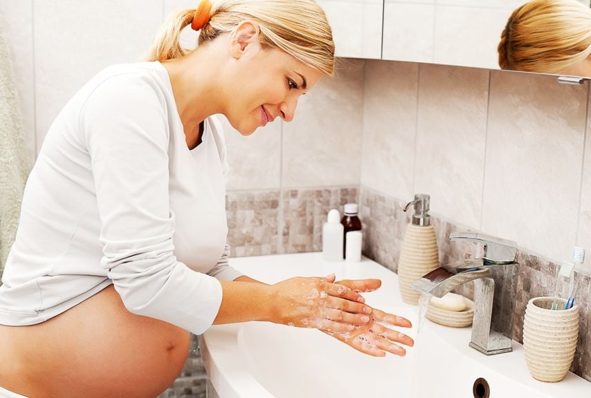 Schwangere wäscht sich die Hände