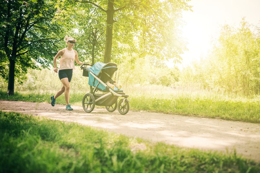 Frau joggt mit Buggy