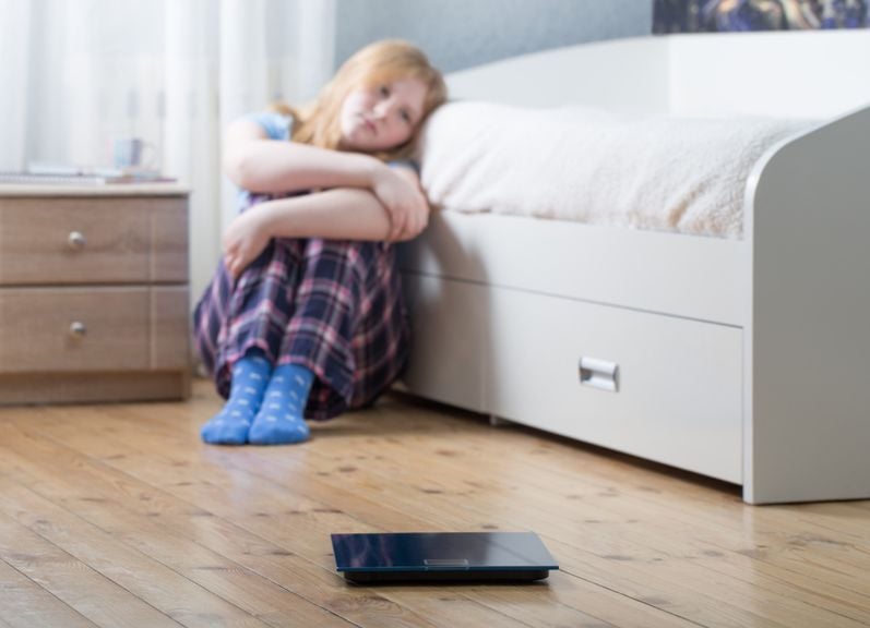 Nachdenkliches Mädchen mit sitzt am Boden