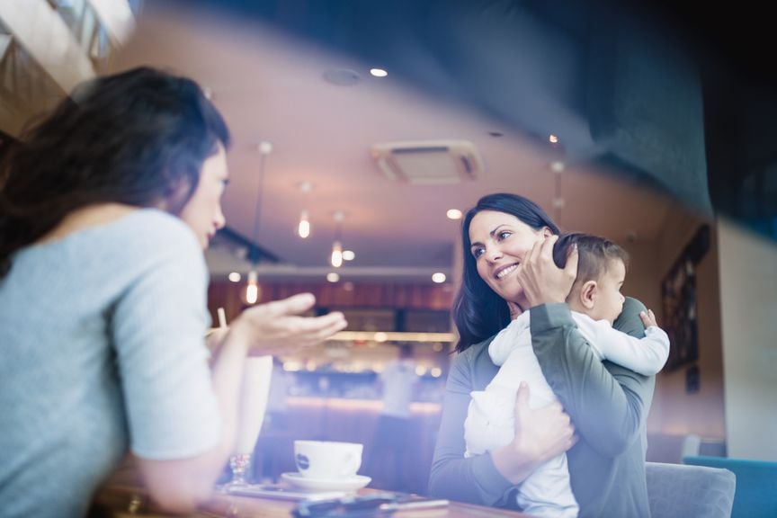 Mutter mit Baby im Gespräch in einem Kaffee