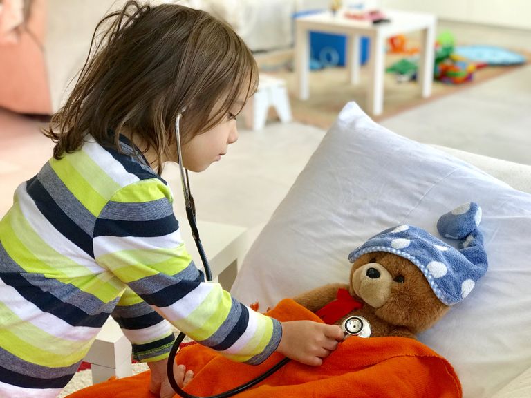 Kind spielt Arzt und Patient mit Teddybär