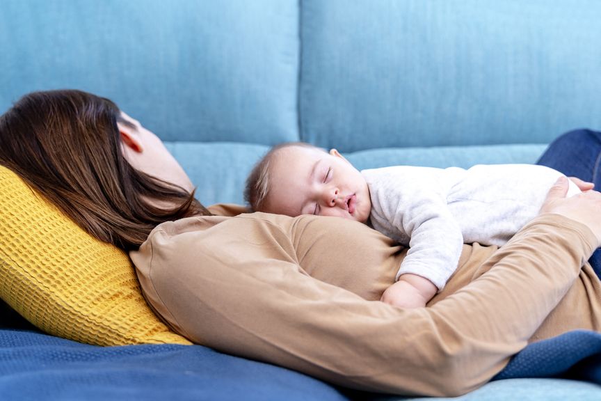 Baby schläft auf dem Bauch der Mutter