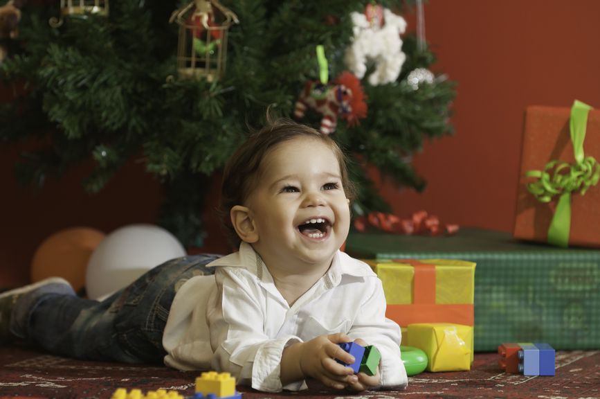 lachendes Kind unterm Weihnachtsbaum