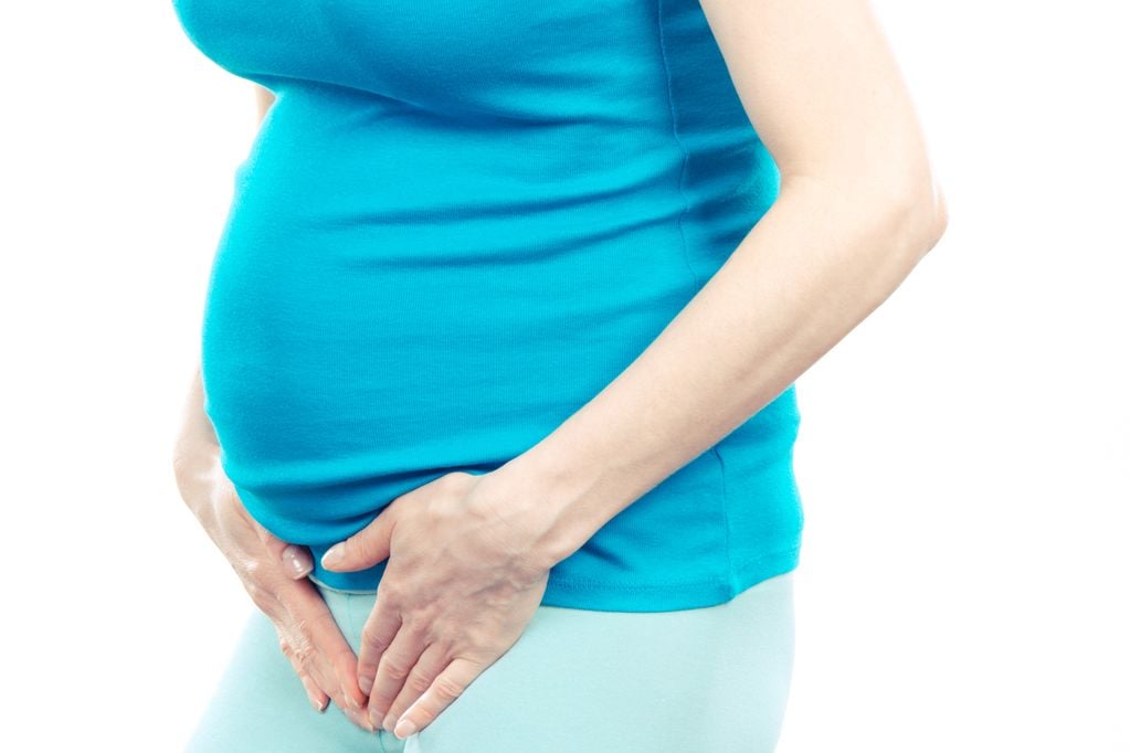 Schwangere hält sich den Unterbauch, Blasenprobleme