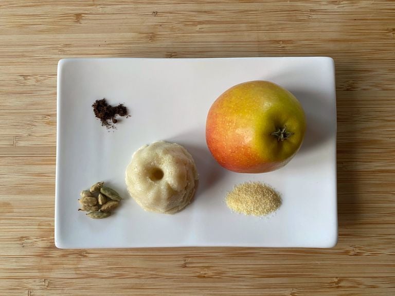 Apfel-Griessköpfli, Apfel, Griess, Kardamomkapseln und Vanillepulver auf einem weissen Teller