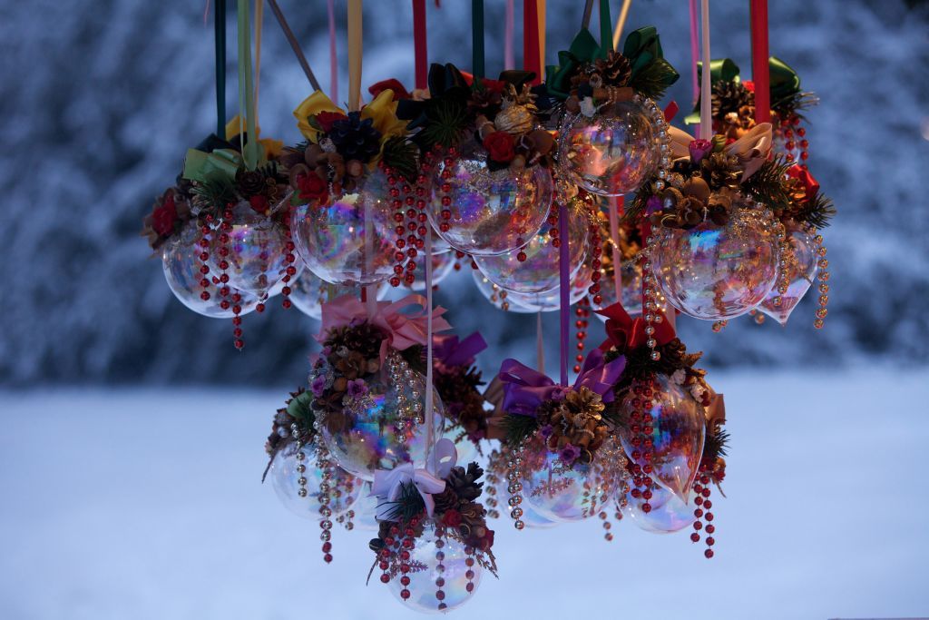 Mit Schleifen, Perlen und Kunstblumen verzierte Weihnachtskugeln