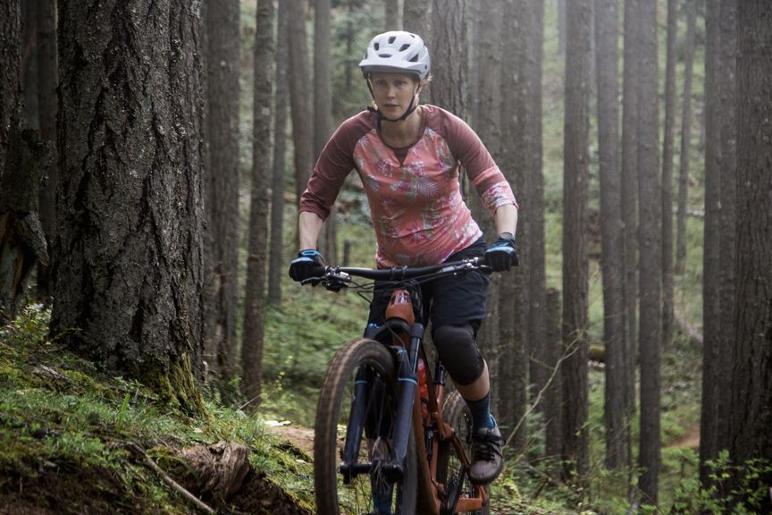 Frau mit Fahrrad im Wald