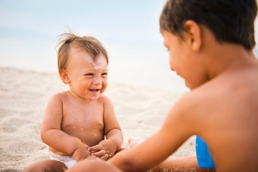 Baby mit Bruder am Strand