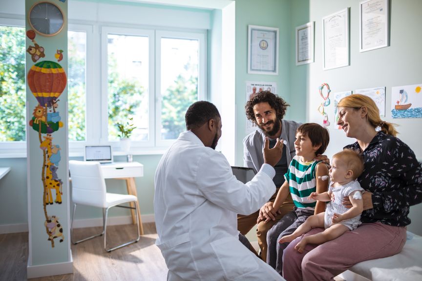 Eltern mit zwei Kindern beim Kinderarzt