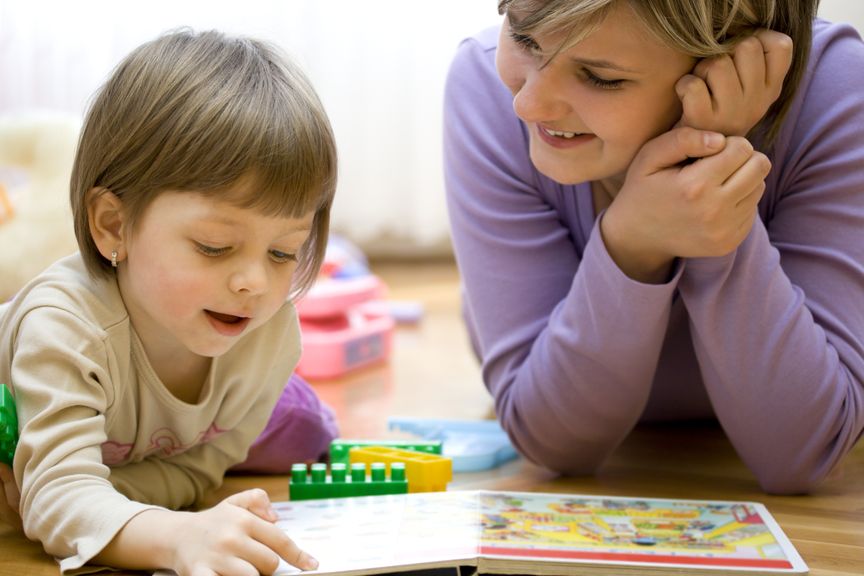 Mutter und Tochter schauen ein Bilderbuch an