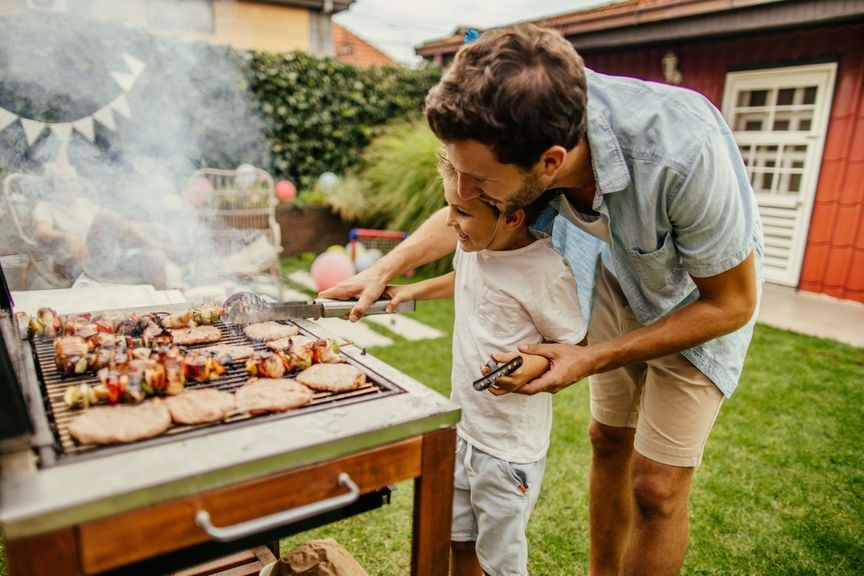 Vater mit Kind am Grill