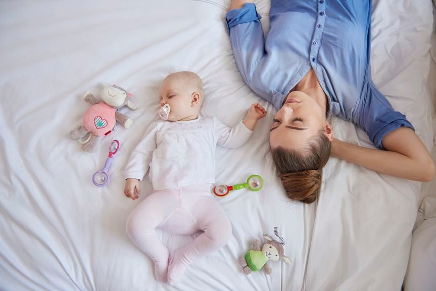 Mutter und Baby schlafen im Bett