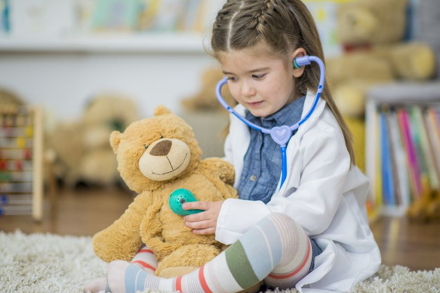 Mädchen spielt Kinderarzt; Herzabhören beim Teddy