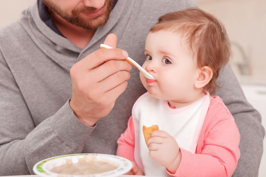 Vater füttert seine kleine Tochter