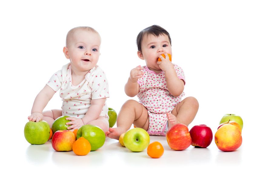 zwei Babys mit diversen Früchten