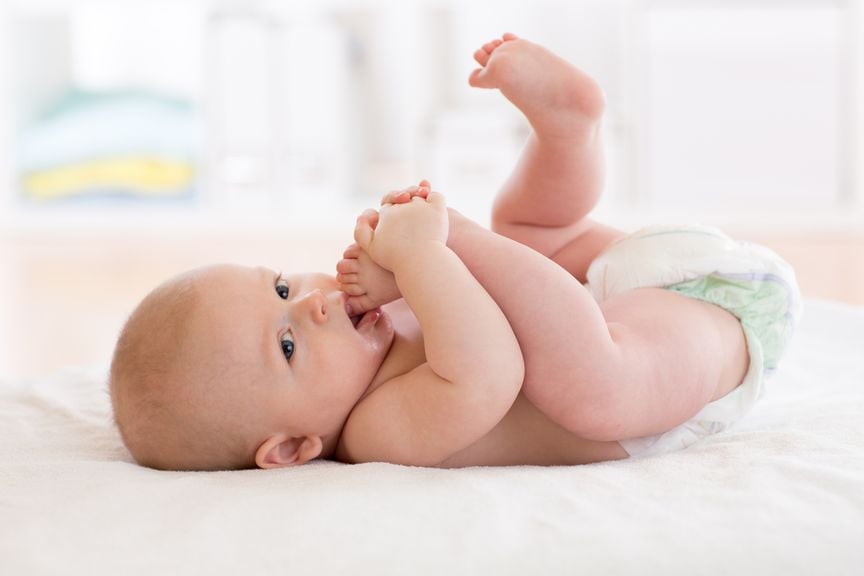 Baby nimmt seine Zehen in den Mund