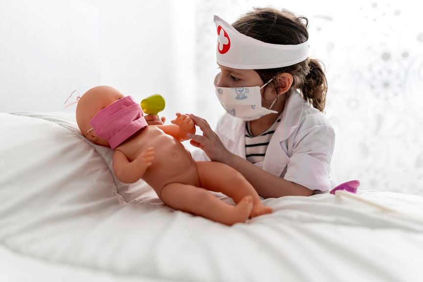 Kind spielt mit Puppe Arzt