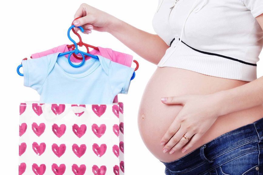 Schwangere mit Einkaufstasche und Babykleider