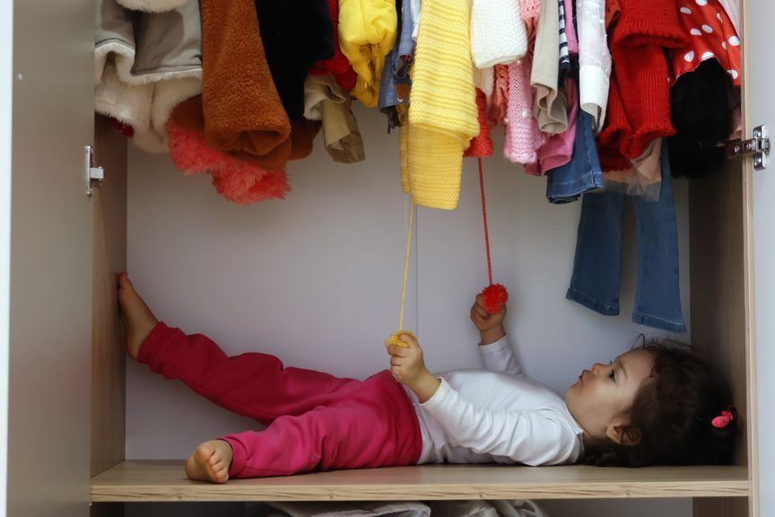 Kind im Kleiderschrank