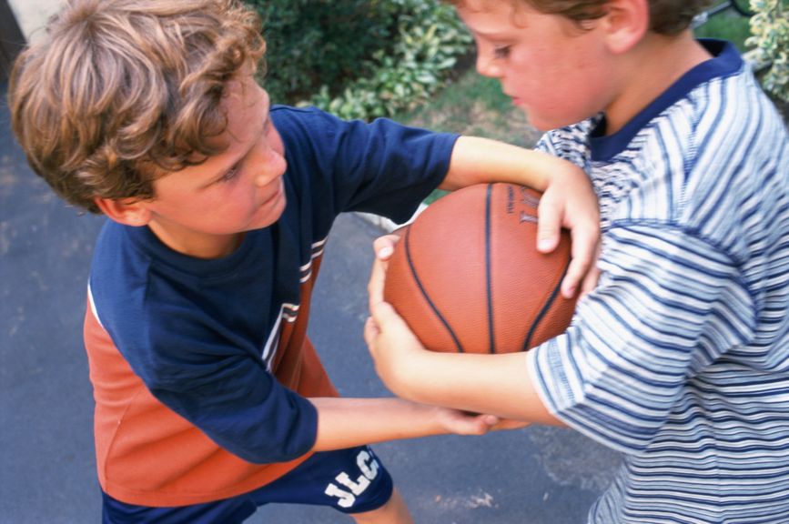 Jungs streiten sich um einen Basketball