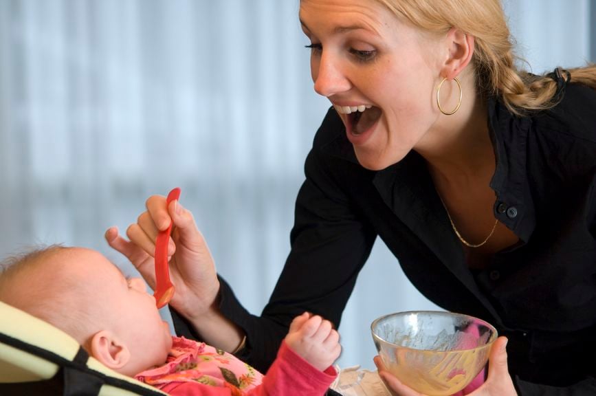 Mutter füttert Baby mit Brei