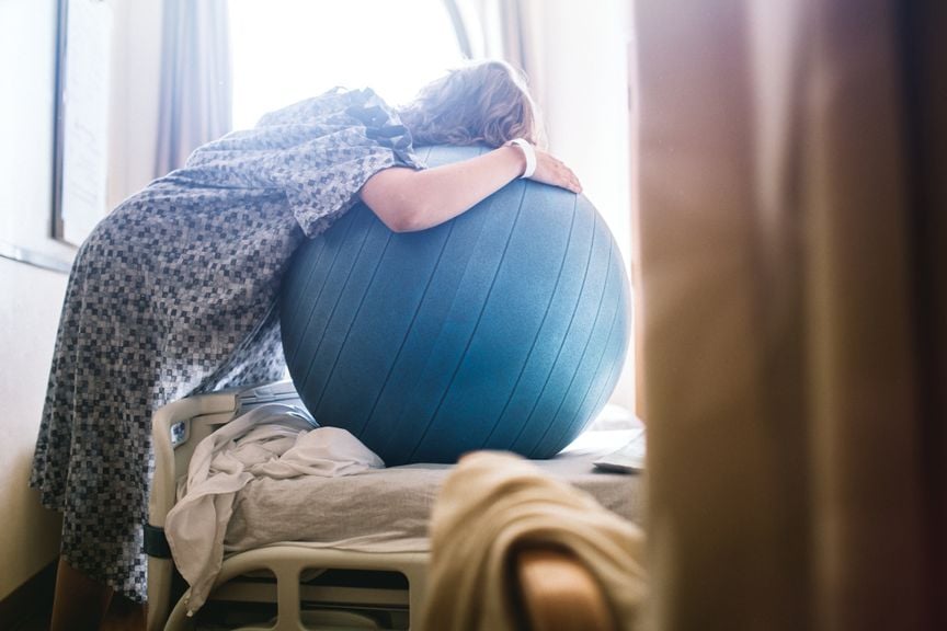 Gebärende lehnt über einen Fitnessball