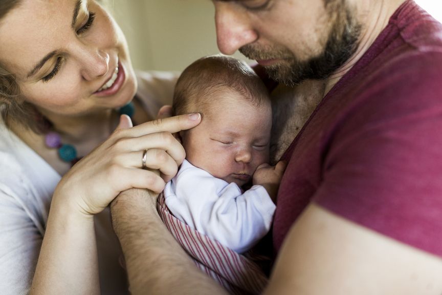Eltern mit neugeborenem Baby im Arm