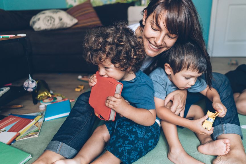 Glückliche Mutter mit zwei Kindern und Unordnung