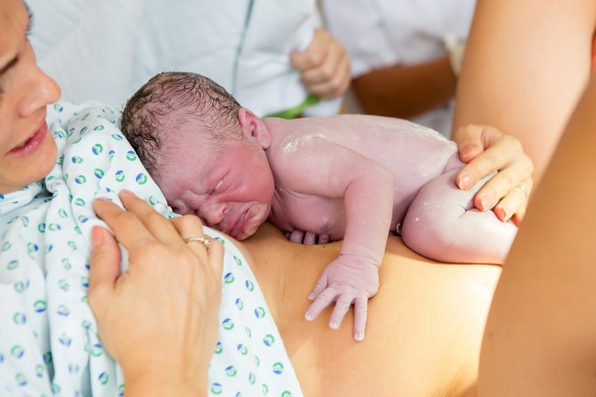 Neugeborenes auf dem Bauch der Mutter, Sekunden nach der Geburt