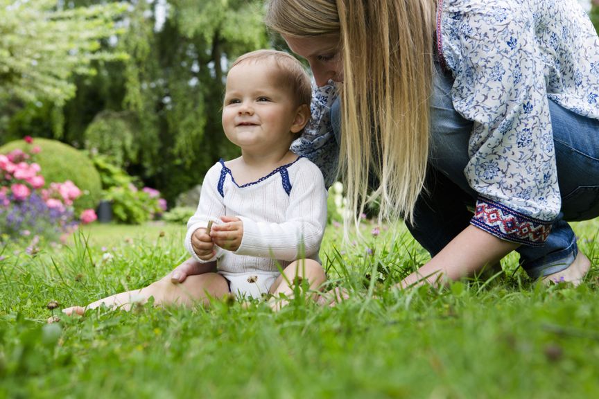 Baby sitzt auf der Wiese