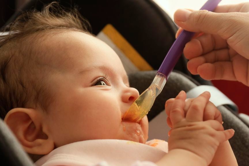 Baby wird mit Brei gefüttert