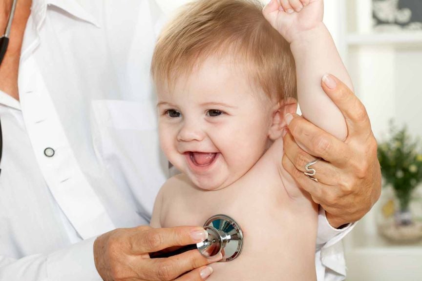 Kinderarzt hört Baby mit dem Stethoskop ab