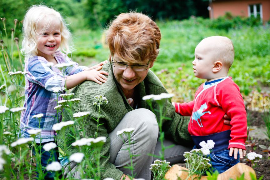 Grossmutter mit zwei Enkeln im Garten